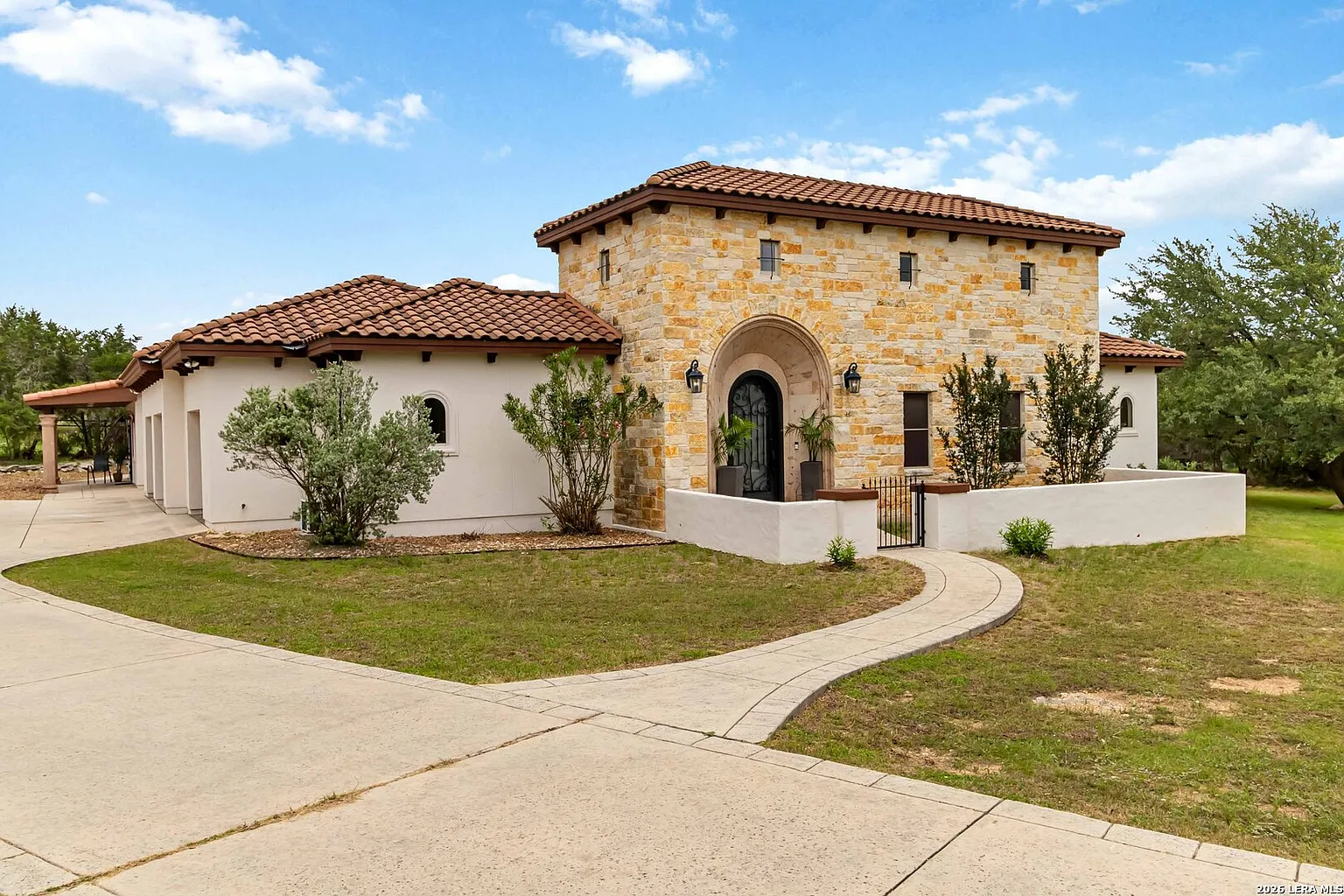 Front entry: limestone tower and arched iron door